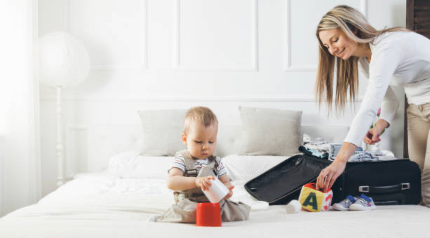 Parent and baby packed and ready to travel with nappy bag romper and muslin wrap essentials